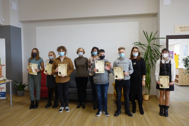 laureaci stoją, trzymają w dłloniach dyplomy