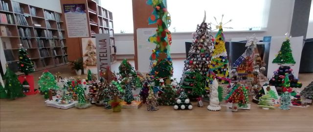 na brązowej podłodze kolorowe choinki, za nimi brązowe regały