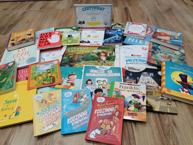 na brązowej podłodze kilkanaście kolorowych książek