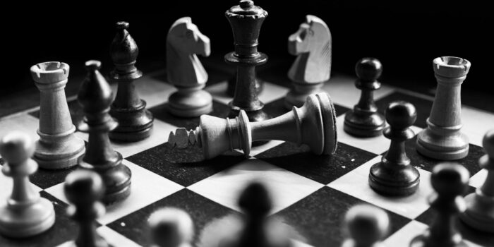 figury szachowe czarne i białe na planszy do gry w szachy biało-czarnej
