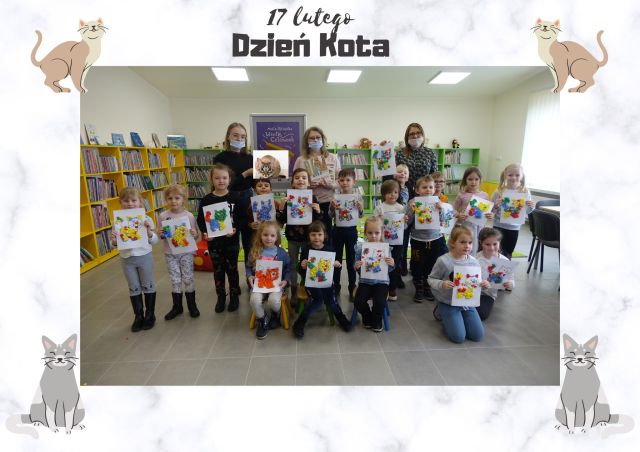 na siwej podłodze klęczą i stoją dzieci w kolorowych ubraniach, w trzecim ostatnim rzędzie stoją trzy kobiety w maseczkach i kolorowych strojach, za nimi zielone i żółte regały