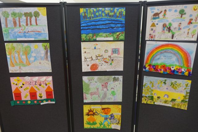 na czarnej tablicy przypięte różne rysunki