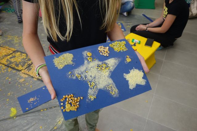 dziewczynka trzyma w rękach wyklejone na niebieskim papierze gwiazdy