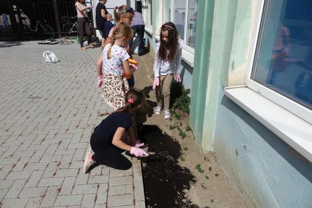 dzieci pielęgnują ogródek, sypią ziemię