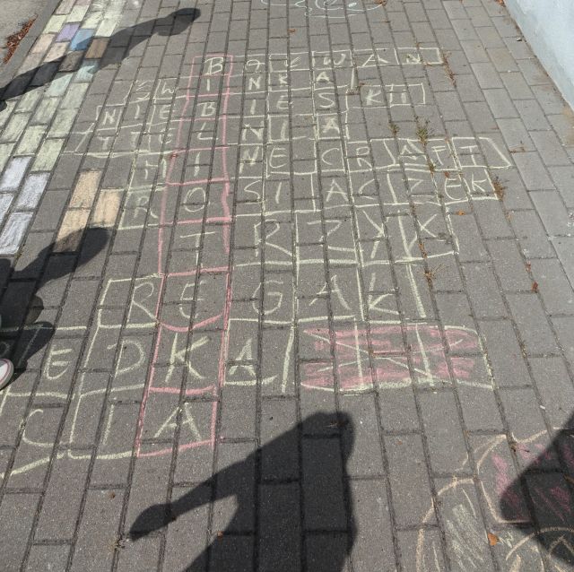 na chodniku narysowana krzyżwka z wypełnionymi polami, powstałe hasło to biblioteka