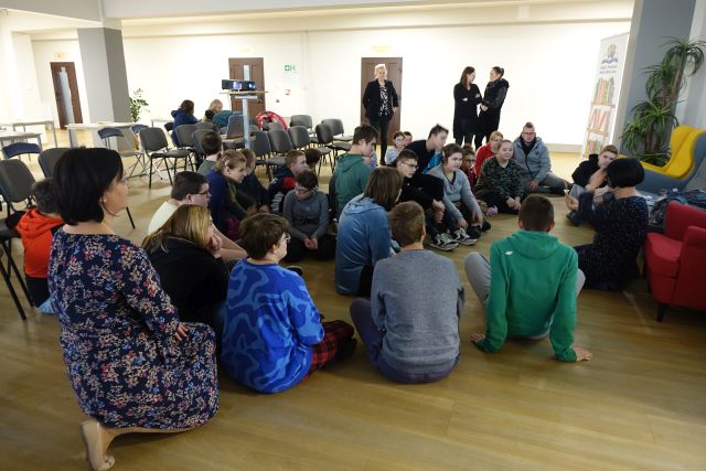 młodzież siedzi na podłodze