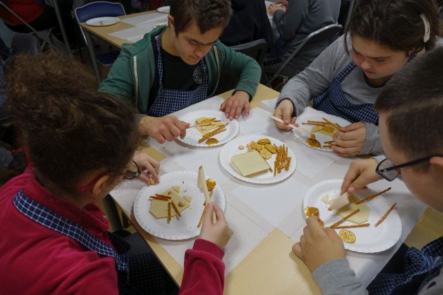 na paierowych talerzykach koty wykonane z wafelków, biszkoptów i paluszków, przy stolikach siedzą chłopcy