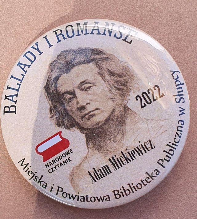 okrągła przypinka, na beżowym tle zdjęćie mężczyzny