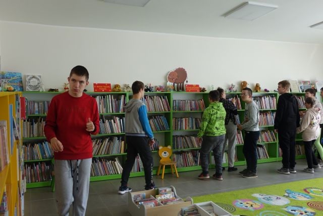 młodzież ogląda książki na regałach