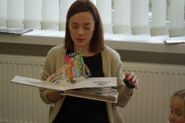 kobieta trzyma rozłożoną książkę