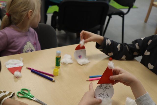 dzieci wykonują z papieru i waty mikołaje