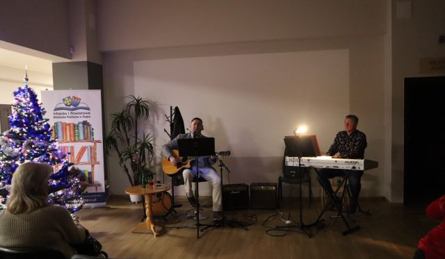 Muzyzy grają na gitarze i klawiszach i wokalista śpiewa