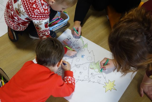 dzieci malują choinkę na dużej kartce