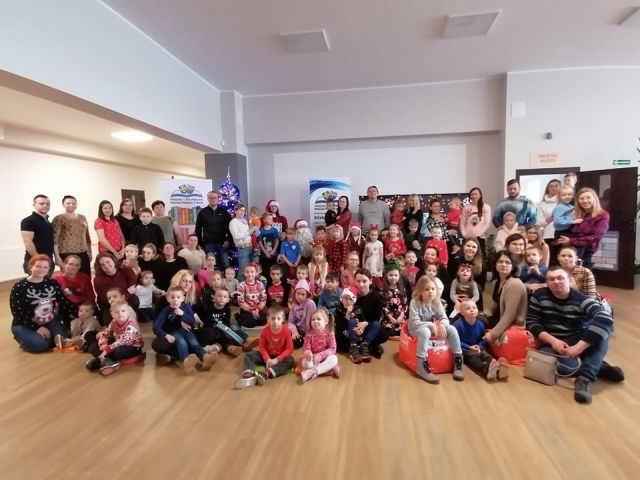 uczestnicy spotkania pozują do zdjęcia z mikołąjem i panią mikolajową