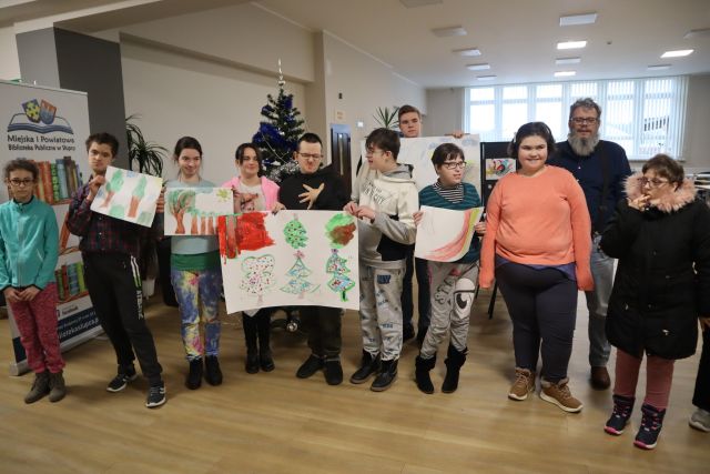 młodzież pozuje do zdjęcia z wykonanymi przez siebie pracami plastycznymi