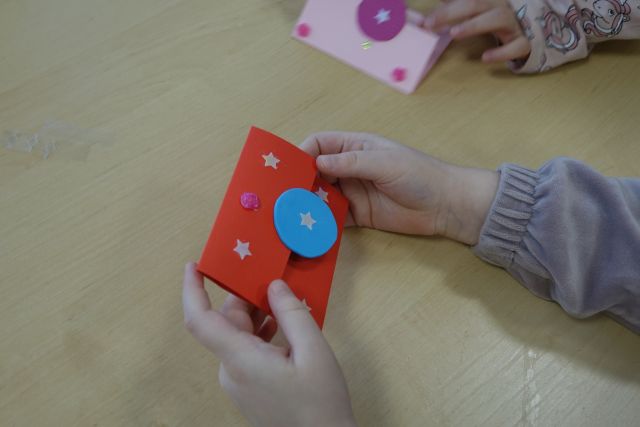 czerwone etui na kartę biblioteczną w dłoni dziecka