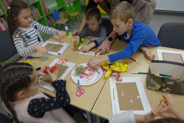 dzieci wykonują z różnych materiałów ramki na zdjęcia