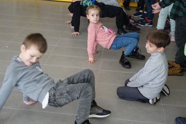 dzieci chodzą jak rak z klockiem na brzuchu, pozostałe dzieci kibicują
