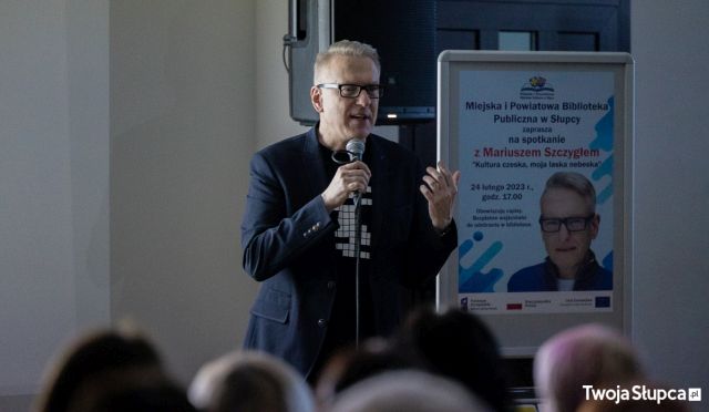 mężczyzna w granatowej marynarce z mikrofonem