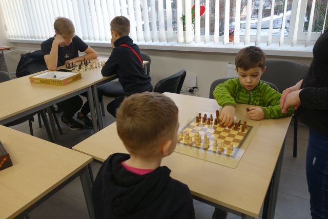 4 młodych szachistów gra w szachy