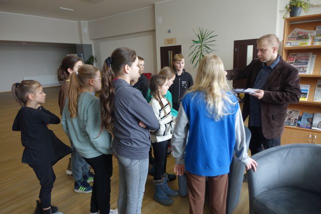 młodzi uczestnicy wysłuchują zadania, któe im daje do wykonania mężczyzna