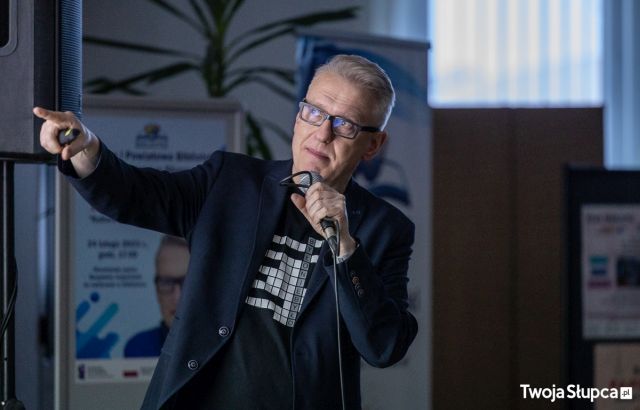 mężczyzna w granatowej marynarce z mikrofonem