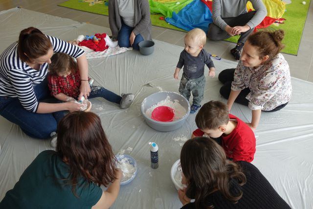 dzieci i rodzice robią śnieg z pianki do golenia i mąki
