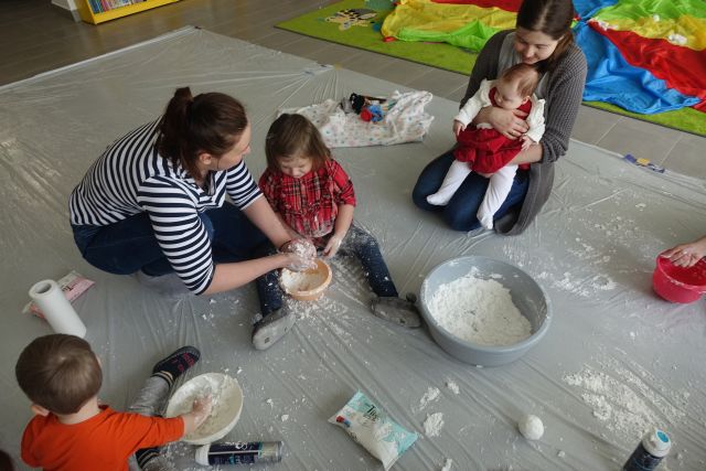 dzieci i rodzice robią śnieg z pianki do golenia i mąki