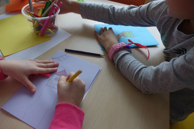 dzieci rysują na kartkach papieru