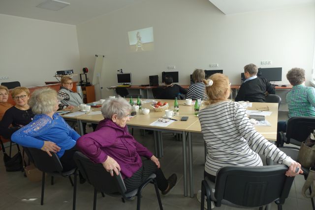 seniorki ćwiczą siedząc na krzesłach