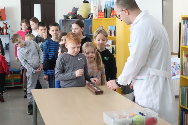 dzieci wykonują doświadczenie z magnesami, pozostali czekają w kolejce