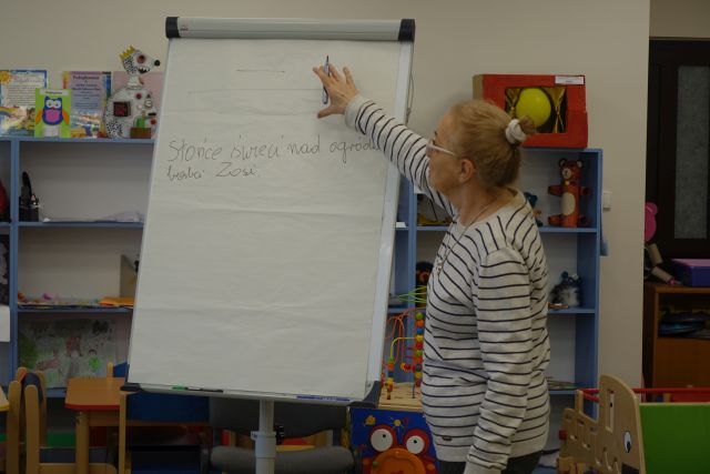 kobieta stoi przed flipchartem