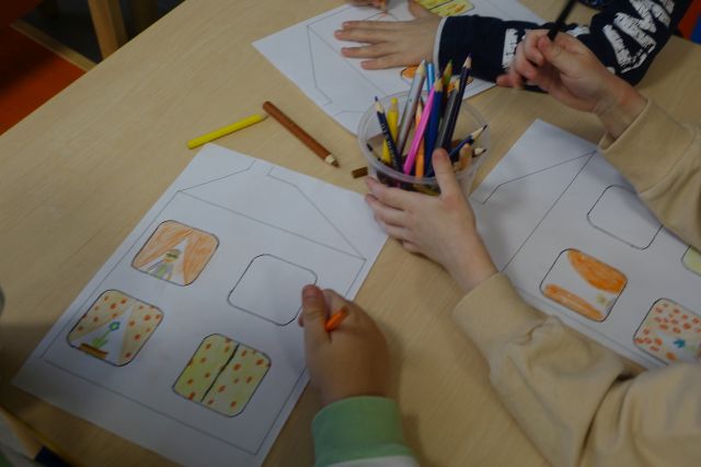 dzieci malują na kartkach domki