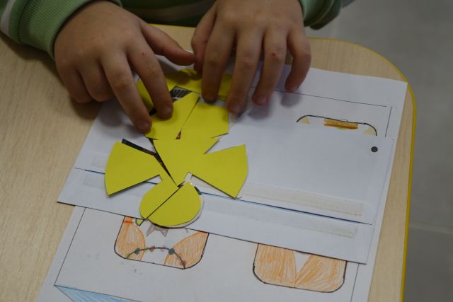 dzieci układają puzle z pociętych żółtych kartek