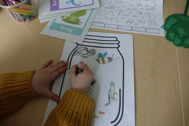 dziecko maluje robaki na kartce z namalowanym słoikiem
