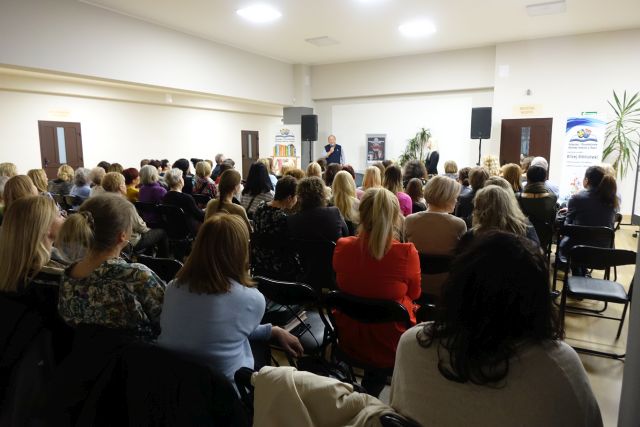 około 100 uczestnikó spotkania siedzi na krzesłach