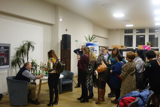 uczestnicy spotkania stoją w kolejce do autora po autograf