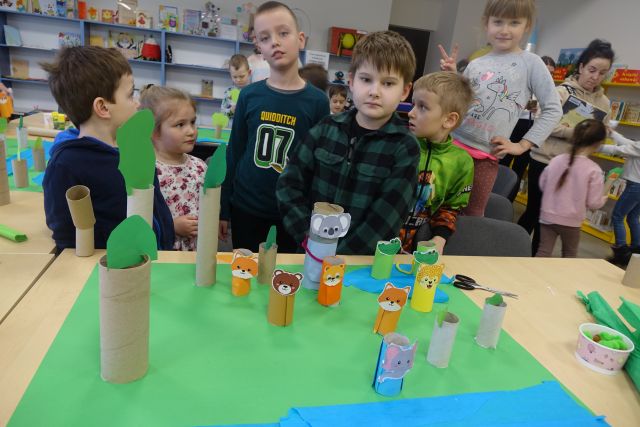 dzieci stoją za stołami, na stołach wykonane przez nich zwierzęta