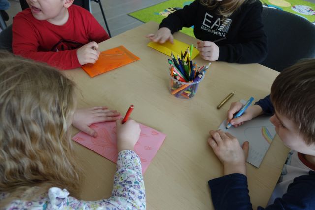 dłonie dzieci rysujące na kartkach