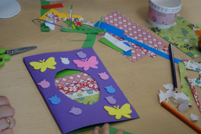 na stole wykonana przez dzieci i rodziców kartka wielkanocna oraz resztki materiałów