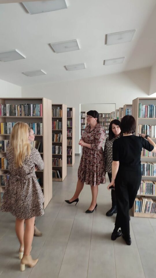 4 kobiety pomiędzy regałąmi z książkami