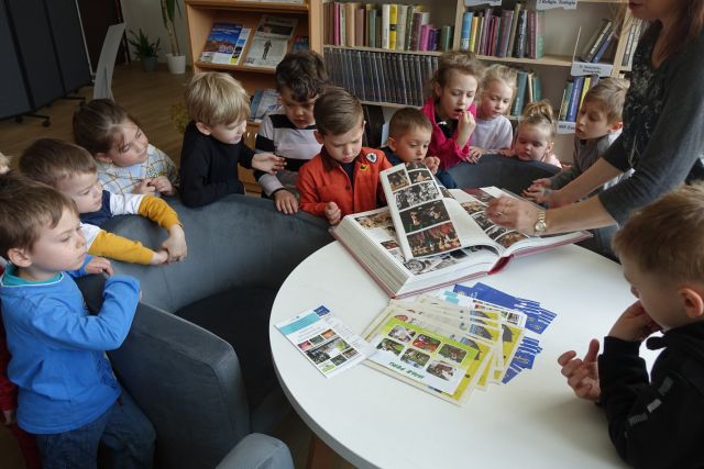 dzieci w czytalni oglądają najcięższą książkę w bibliotece