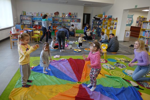 Klub Malucha dzieci i rodzice bawią się w bibliotece