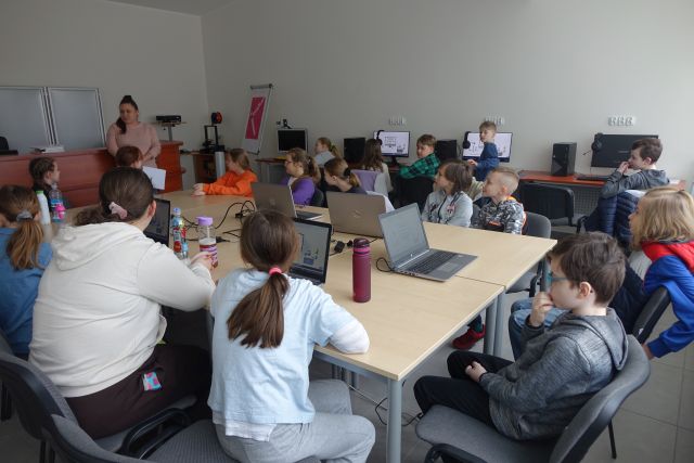 młodzież siedzi w sali komputerowej