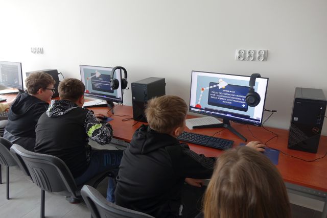 Młodzież siedzi przed komputerami