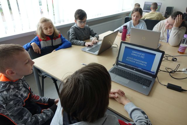 Młodzież pracuje przy laptopach