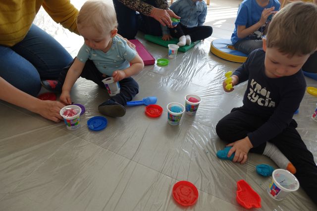 dzieci na podłodze lepią w ciastolinie