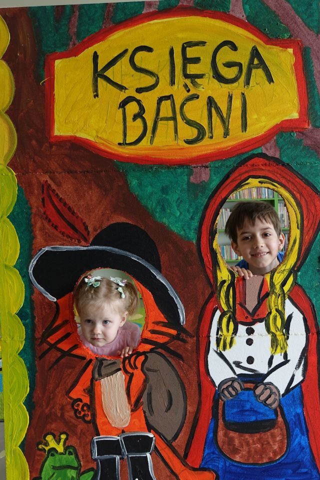 dziewczynka i chłopiec pozują do zdjęcia w fotobudce