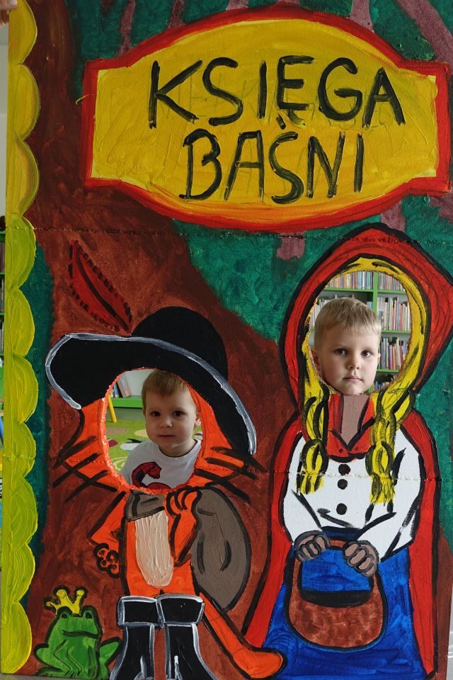 dziewczynka i chłopiec pozują do zdjęcia w fotobudce