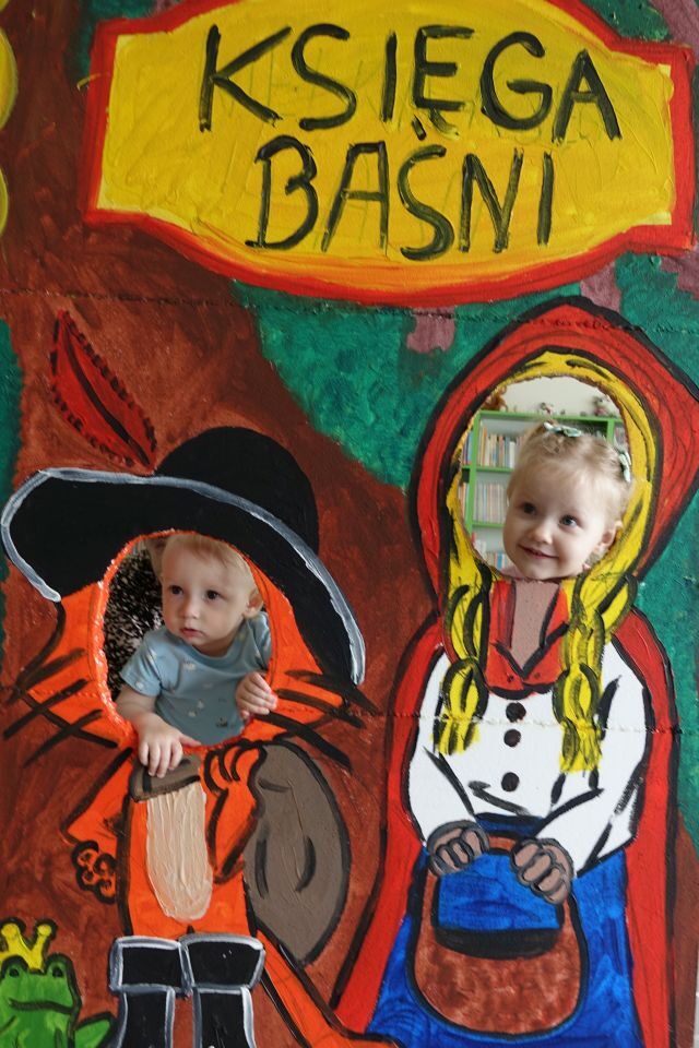 dziewczynka i chłopiec pozują do zdjęcia w fotobudce